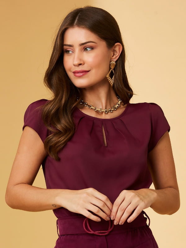 Modelos de blusas femininas: modelo com uma blusa de crepe detalhe gota cor ameixa.