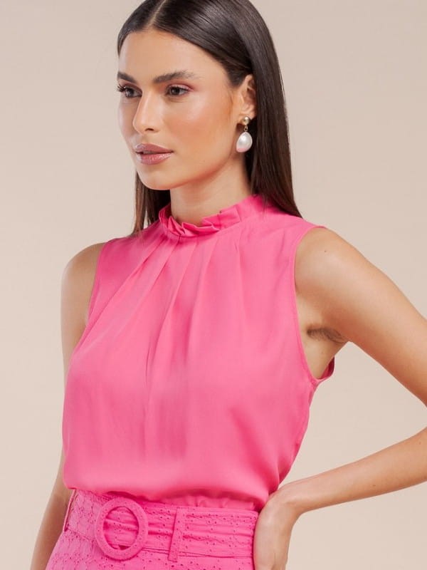 Modelos de blusas femininas: modelo vestindo uma blusa regata de crepe básica com pregas rosa.
