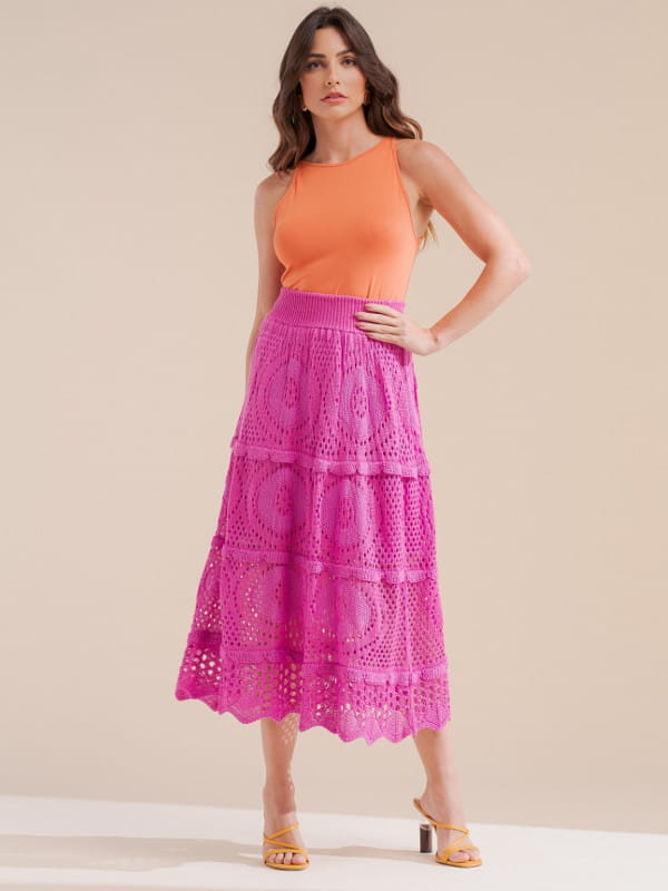 Peças e tendências que rendem looks para ficar elegante: modelo com uma saia de tricot rosa.