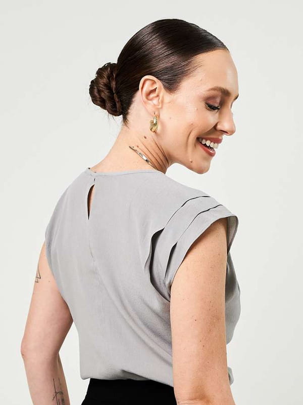 Roupa social feminina: modelo vestindo uma blusa de viscose creponada cinza com pregas - costas.