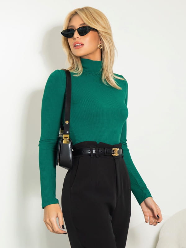 Que cor combina com preto: modelo vestindo uma blusa feminina de malha canelada modelagem slim com calça verde.