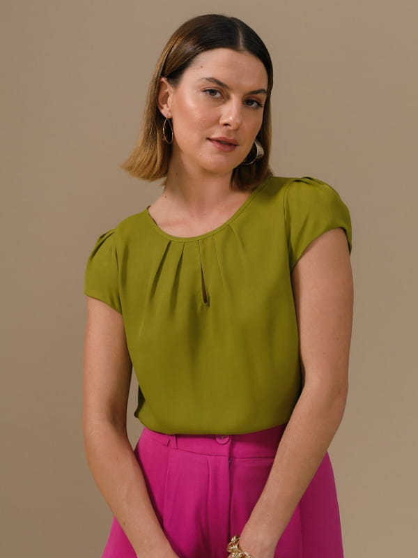 Roupas femininas para trabalhar: modelo vestindo uma blusa de crepe básica detalhe gota verde oliva.