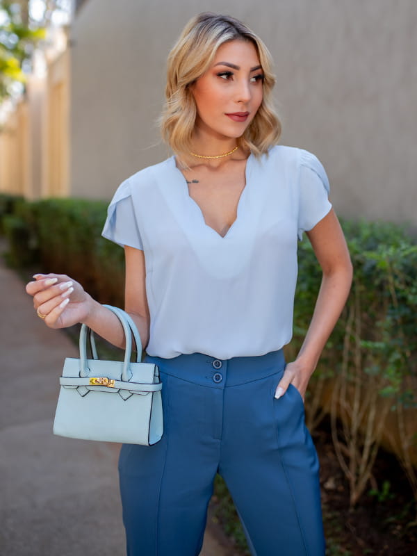 Roupas femininas para trabalhar: modelo com uma blusa de crepe decote nuvem azul claro.