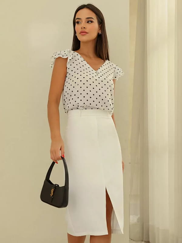 Conjunto de saia e blusa social: modelo vestindo uma saia midi com fenda frontal branca.