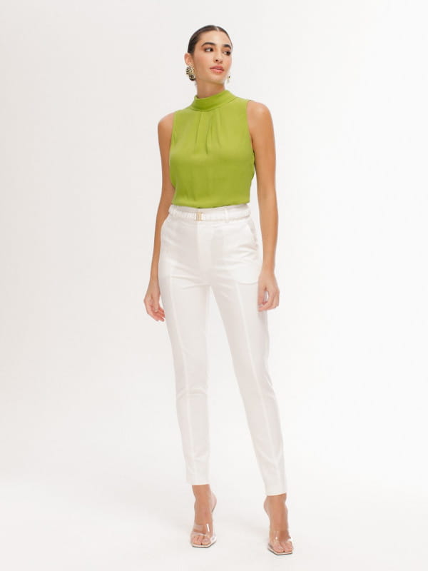 Truques para mulheres altas: modelo com uma blusa verde e calça off white.
