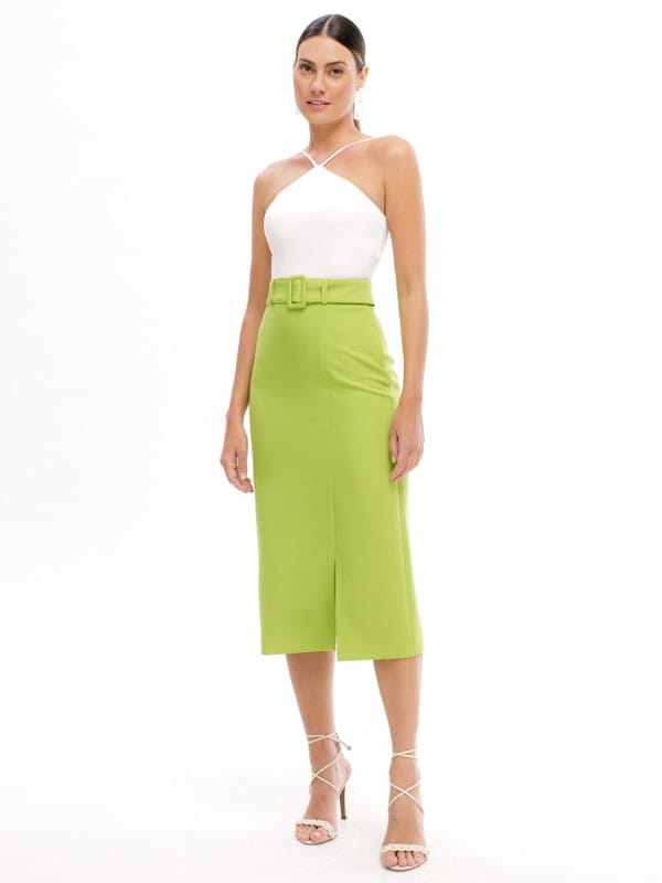 Truques para mulheres altas: modelo vestindo uma blusinha off white e saia midi verde.