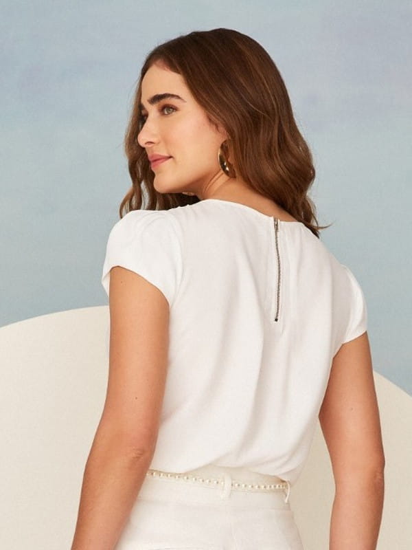Blusas femininas para uniforme: modelo vestindo uma blusa de crepe branca com detalhe gota - costas.