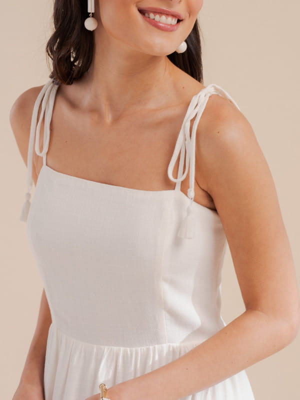 Vestido longo branco para ano novo: modelo com um vestido em linho midi com alça off white - detalhe.